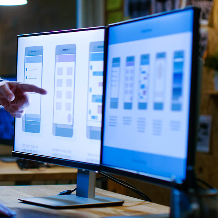 A man points at a laptop screen. An interface mockup on a screen.